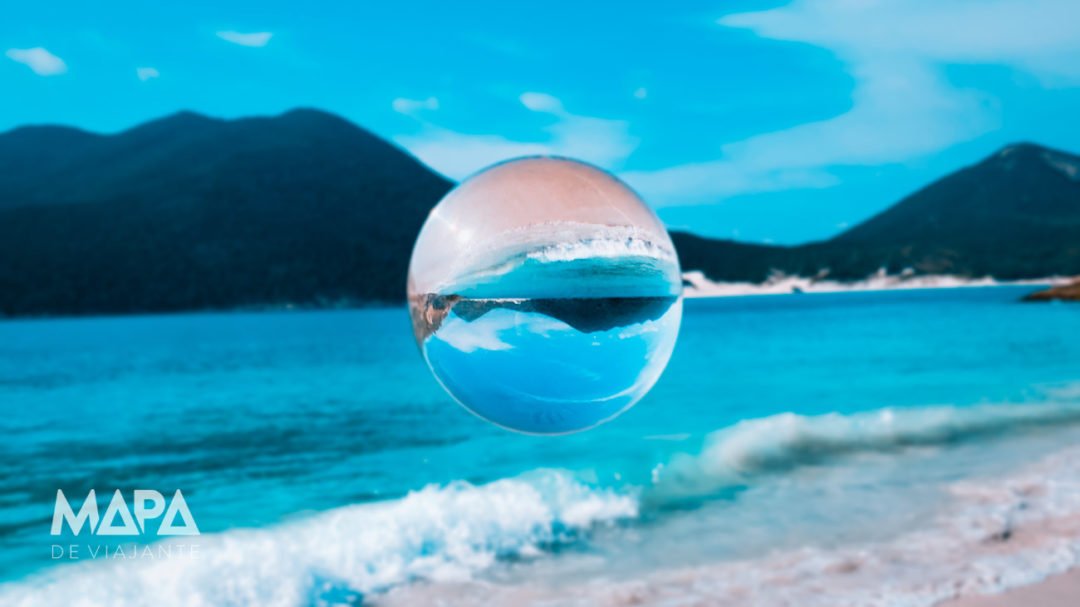 Foto com bola de cristal no Pontal do Atalaia com a praia do Forno ao fundo.